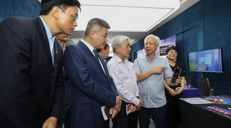 越南经济时报/VnEconomy总经理兼总编辑Dao Quang Binh先生(右二)向出席2026年越南-亚洲DX峰会的前科学技术部部长Nguyen Quan(右三)和其他代表介绍Asko Meet。 -(照片:越南经济时报)