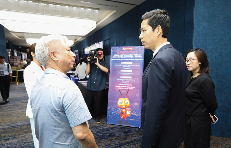 越南经济时报/VnEconomy总经理兼总编辑Dao Quang Binh先生(左)与MISA集团总经理Le Hong Quang先生分享越南制造的人工智能解决方案Askonomy。-(照片:Viet Dung)