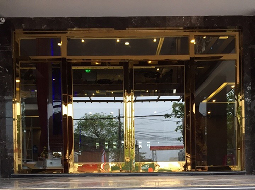 Cửa thủy lực khung bao kính inox vàng