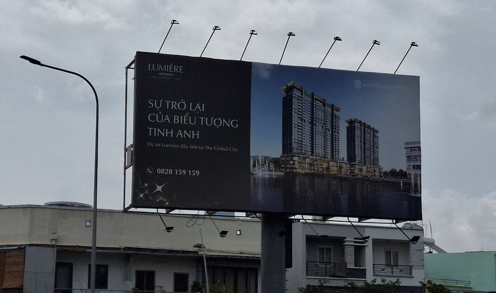 待售公寓广告牌，胡志明市的路边。” width=